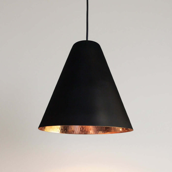 Black pendant light with copper interior on a white background