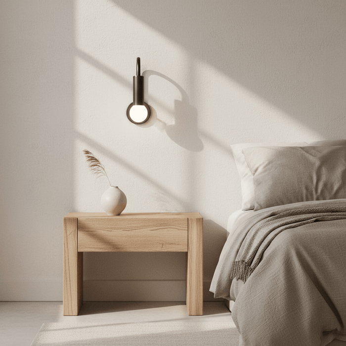 Modern wall light fixture with a single bulb on a dark background