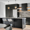 Two small modern smoked glass pendant lights over contemporary kitchen island