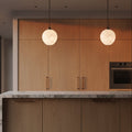 White glass pendant lights over modern kitchen island