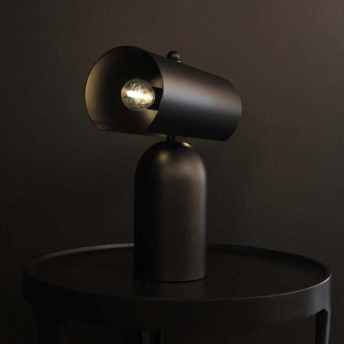 Forma Rechargeable Table Lamp on a table, showcasing its sleek Matt Black finish and unique design.