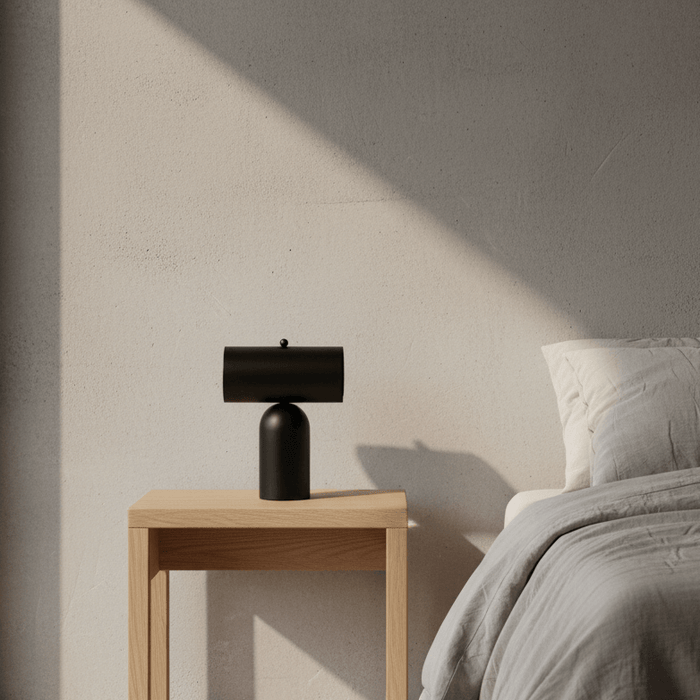 Forma Rechargeable Table Lamp placed on a wooden bedside table in a softly lit bedroom.