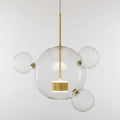 Modern pendant light with clear glass spheres and gold accents on a white background