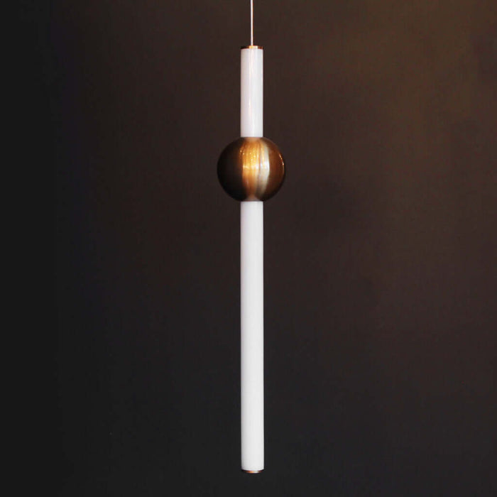 Pendant light with a white cylindrical shade and copper spherical fixture on a dark background