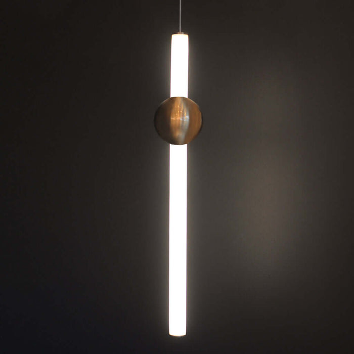Modern pendant light with a cylindrical shade and spherical copper fixture on a dark background