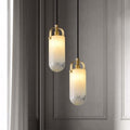 Two cylindrical Santina pendants with gradient textured glass shades and Brushed Brass detailing, hanging against a dark background.