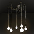 A modern multi-light pendant chandelier with six hanging Edison-style bulbs suspended from a polished metal ceiling canopy by long cords, shown against a dark studio background.