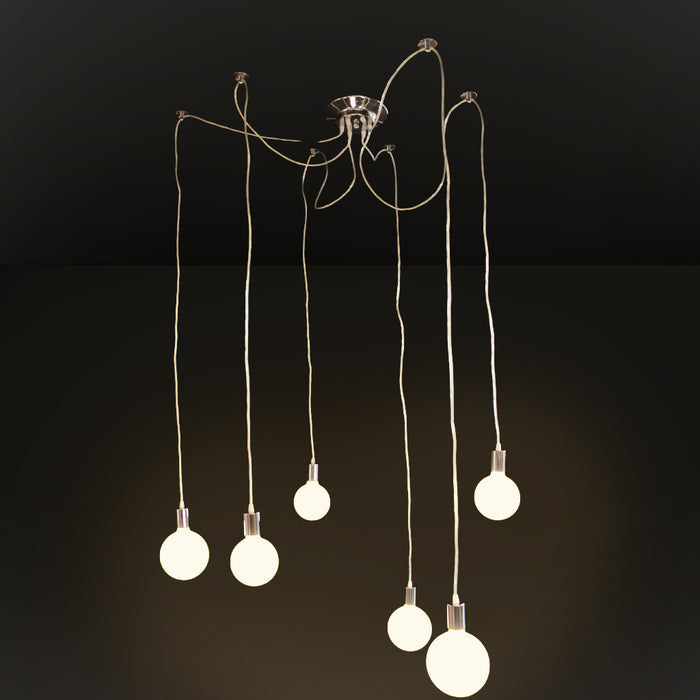 A modern multi-light pendant chandelier with six hanging Edison-style bulbs suspended from a polished metal ceiling canopy by long cords, shown against a dark studio background.