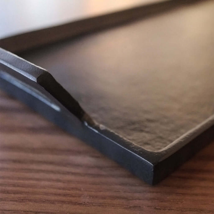 Dark metal tray on a wooden surface