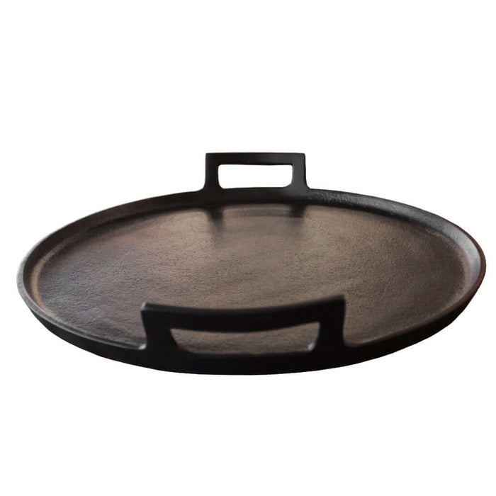 Black cast metal tray with handles on a white background