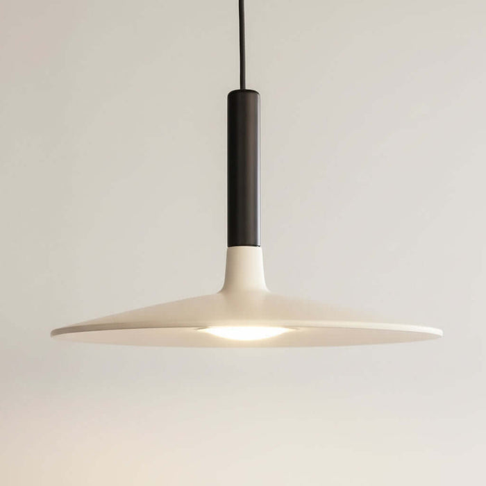 Modern pendant light with a dark fixture on a black background